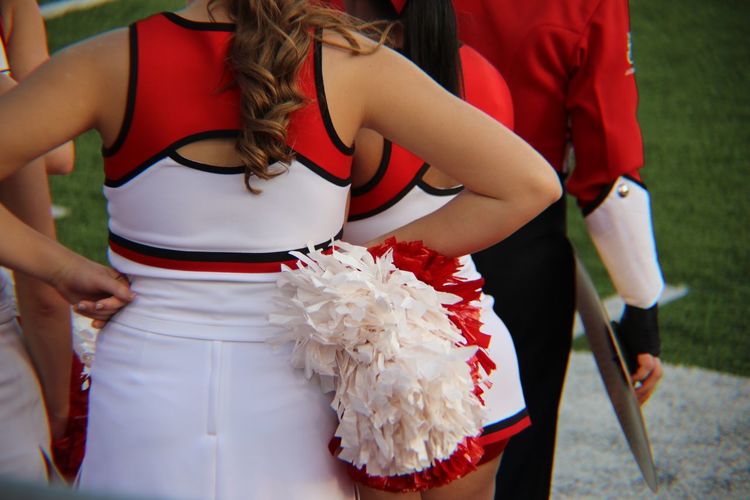 Rear view of cheerleader standing outdoors