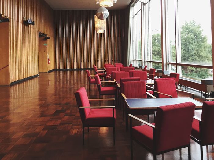 Empty chairs and tables by window in kino international