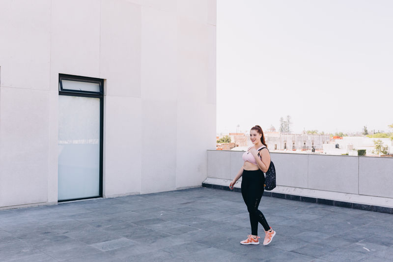 Full length of woman walking in urban setting 