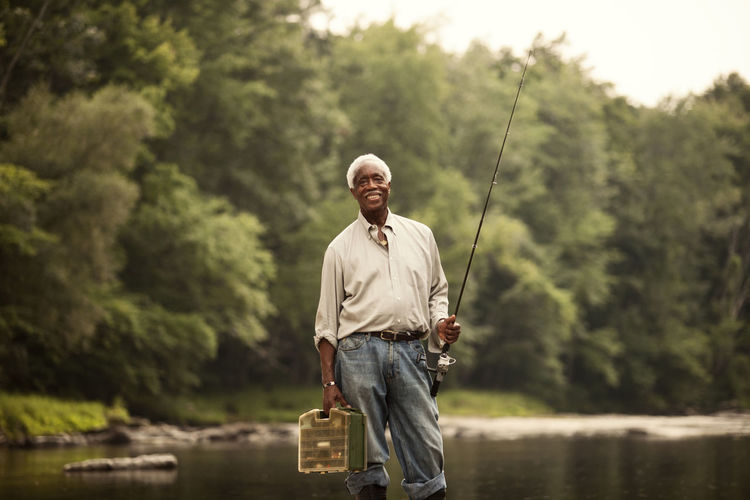Portrait of man with fishing rod and basket