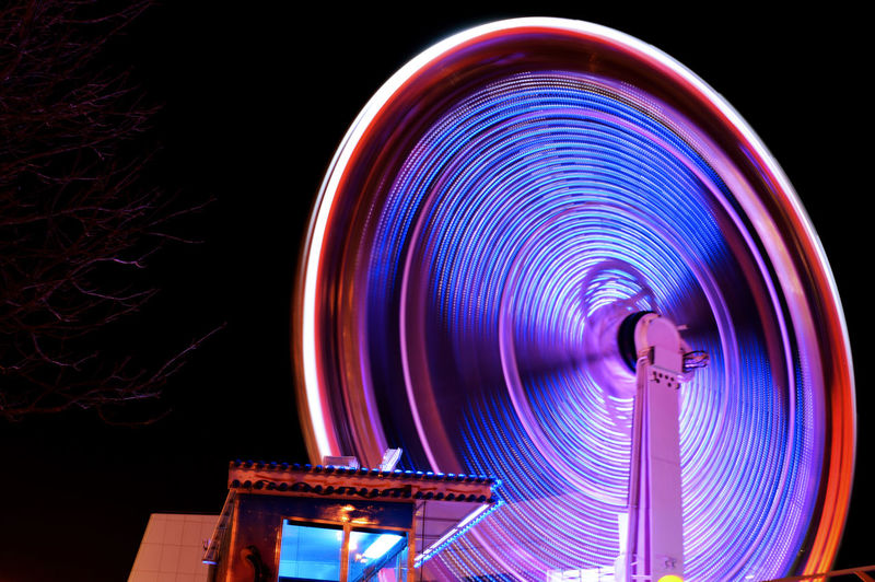 Blurred motion of ferris wheel at night