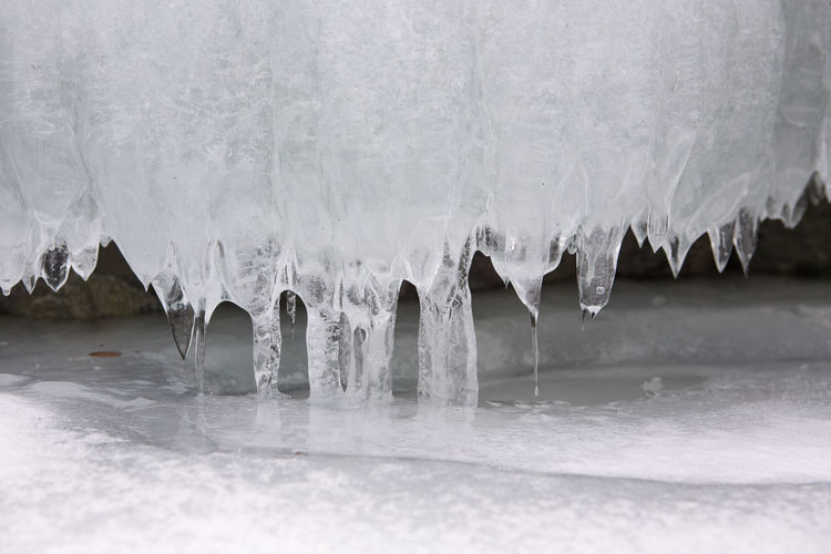 View of beautiful drawings on ice from cracks on the surface of lake teletskoye in winter, russia