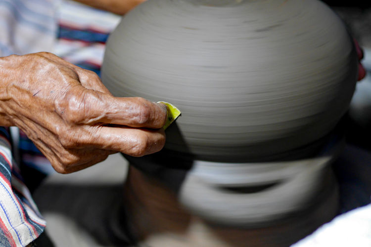 Cropped hand making pottery
