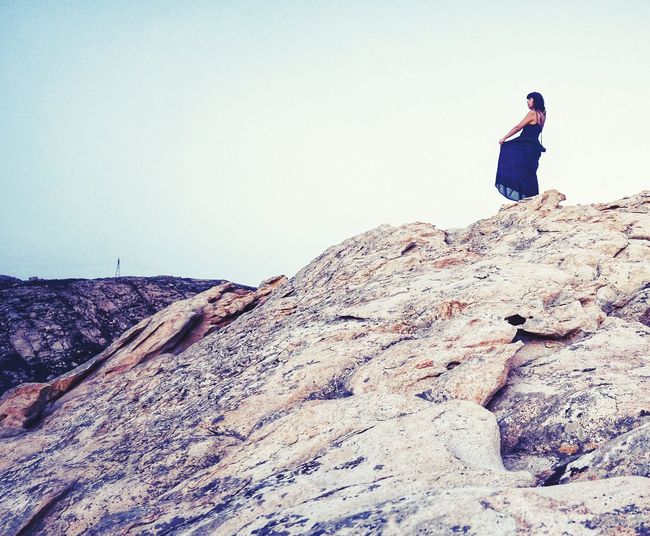 Full length of man standing on rock against sky