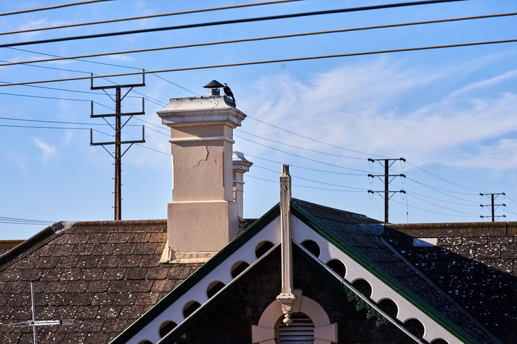 Low angle view of chimney on roof against sky