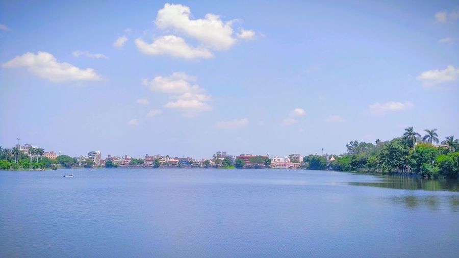 Scenic view of lake against sky in city