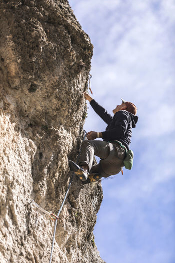 Climber hanging on rope on rough cliff