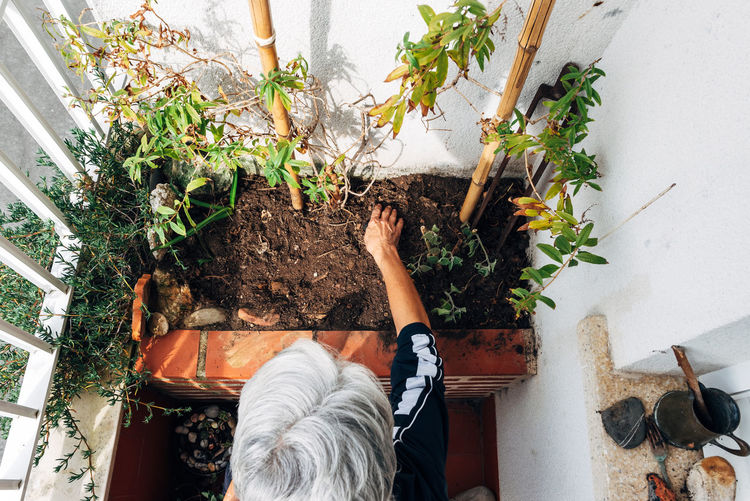 Old woman gardening on balcony