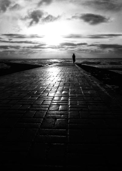 Distance shot of a person overlooking calm sea