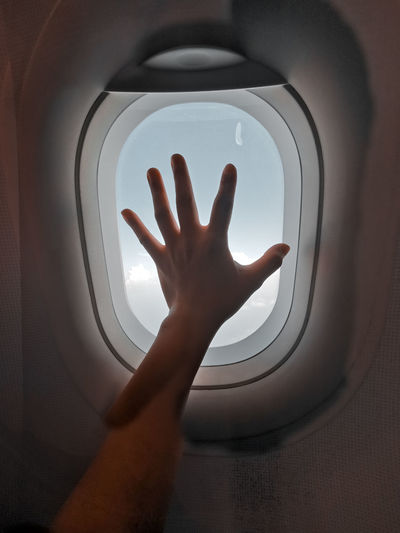 Close-up of human hand on window