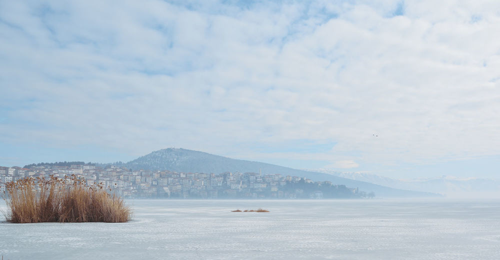 Kastoria and lake orestiada, frozen cover with snow, a cloudy day