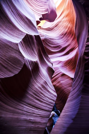 Cropped image of woman standing amidst rock formations at antelope canyon