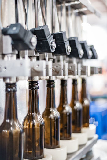 Brown glass bottles are filled with freshly brewed craft beer