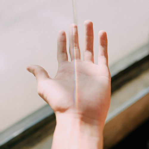 Close-up of human hand against wall