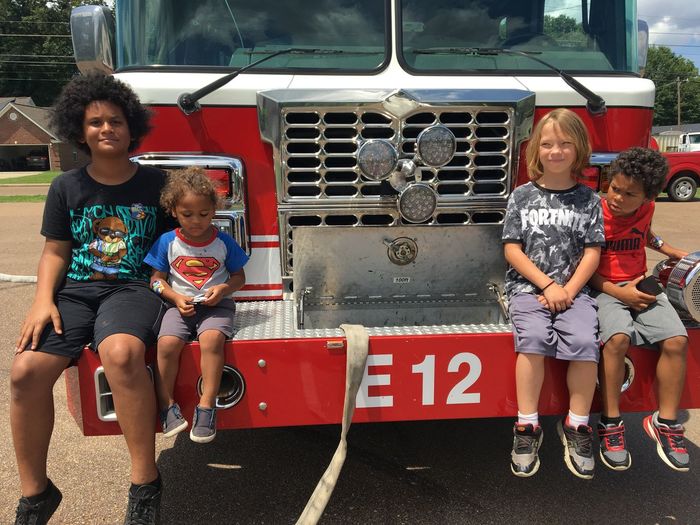City boys enjoying a hot day with the fire truck