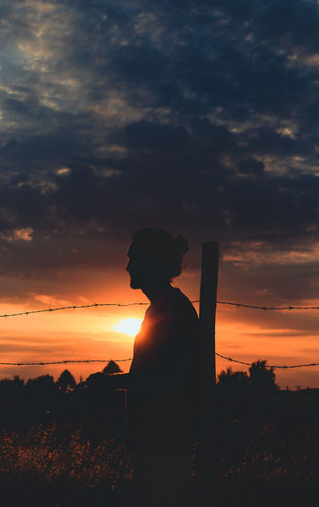 Silhouette person standing against sky during sunset