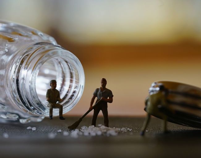 Close-up of figurines with bottle on table
