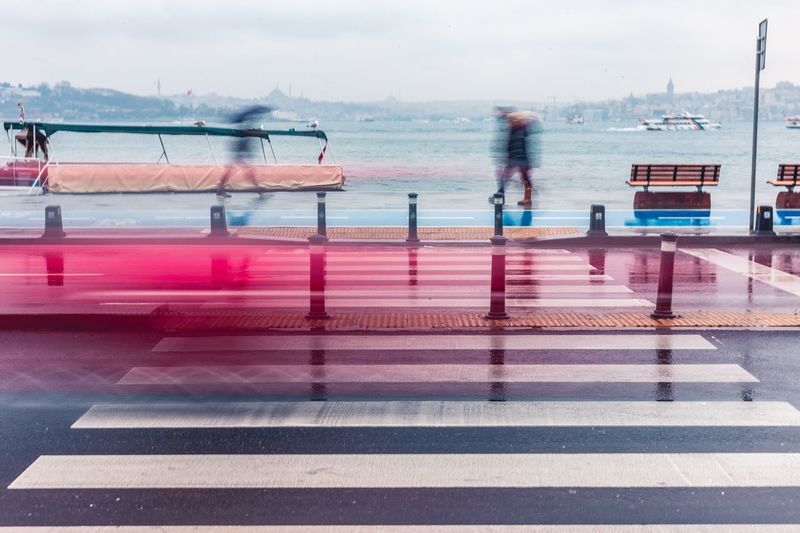 Digital composite image of people walking by sea in city