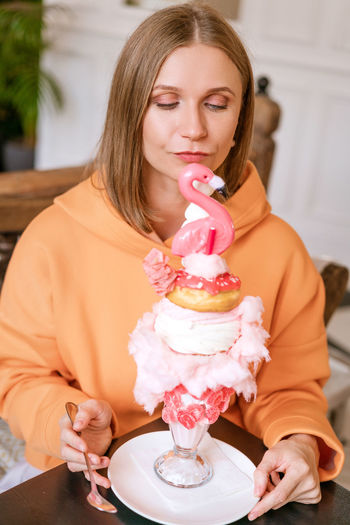 Midsection of woman with ice cream on table