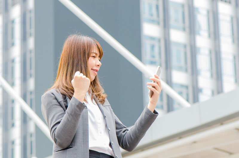 Businesswoman using phone outdoors