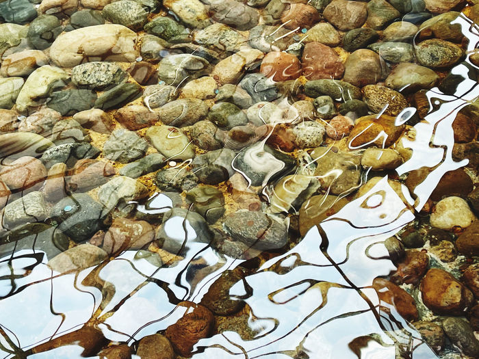 Full frame shot of pebbles in water