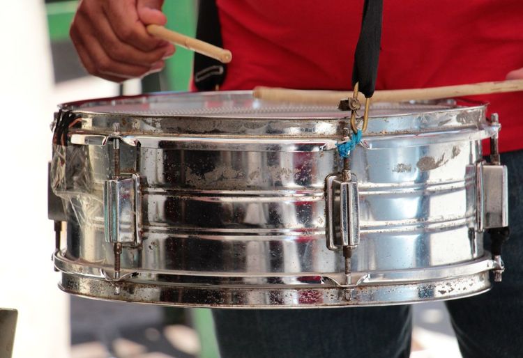 Midsection of musician playing drum