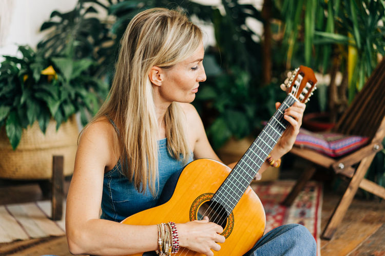 Portrait of romantic woman playing acoustic guitar