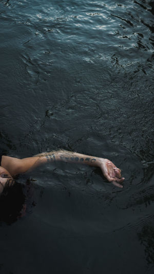 Cropped hand of woman swimming in lake