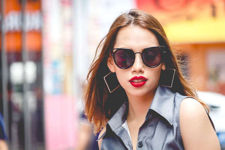 Close-up of beautiful young woman wearing sunglasses in city 