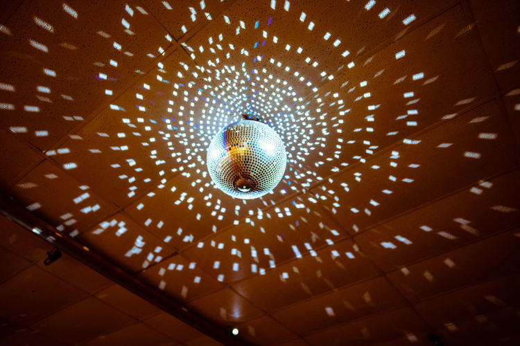 Low angle view of illuminated pendant lights hanging from ceiling