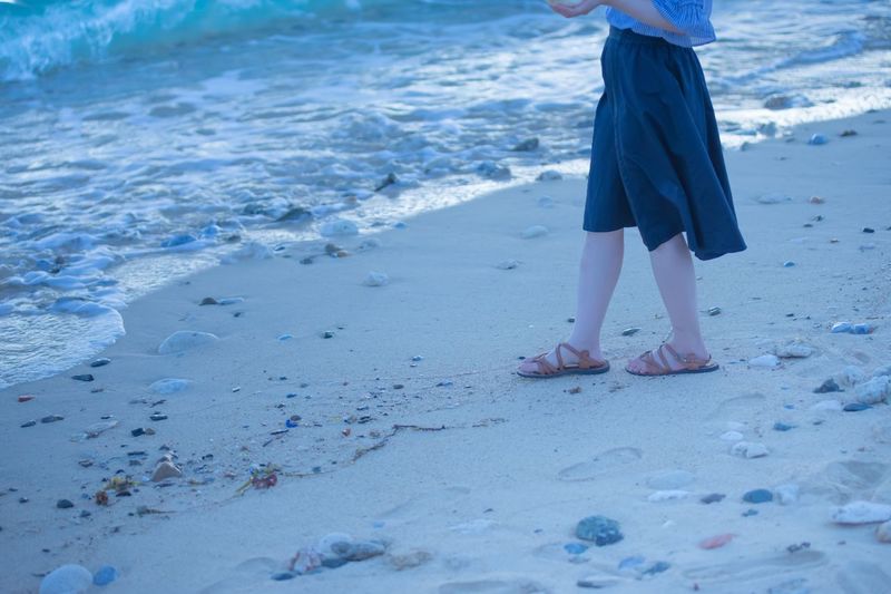 Low section of child standing on beach