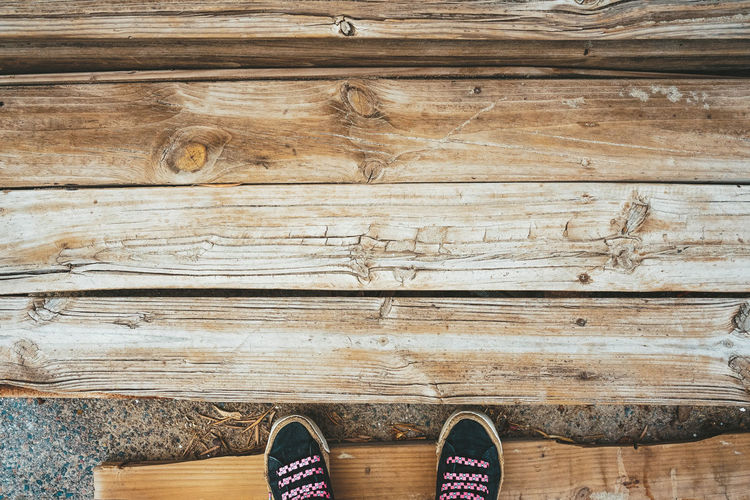 Low section of person standing on wooden floor