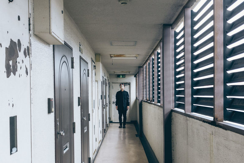 Man wearing animal mask in corridor