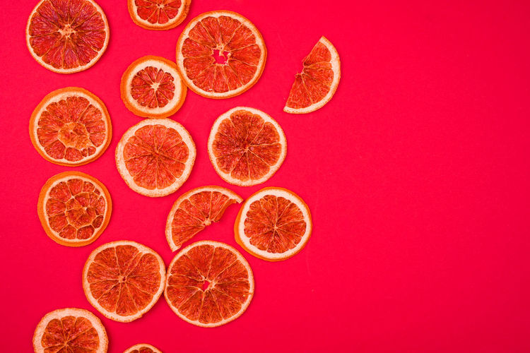High angle view of orange fruit against colored background