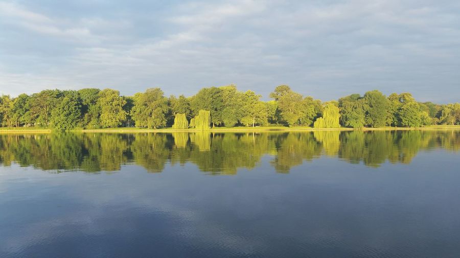 Scenic view of lake by trees against sky at treptower park