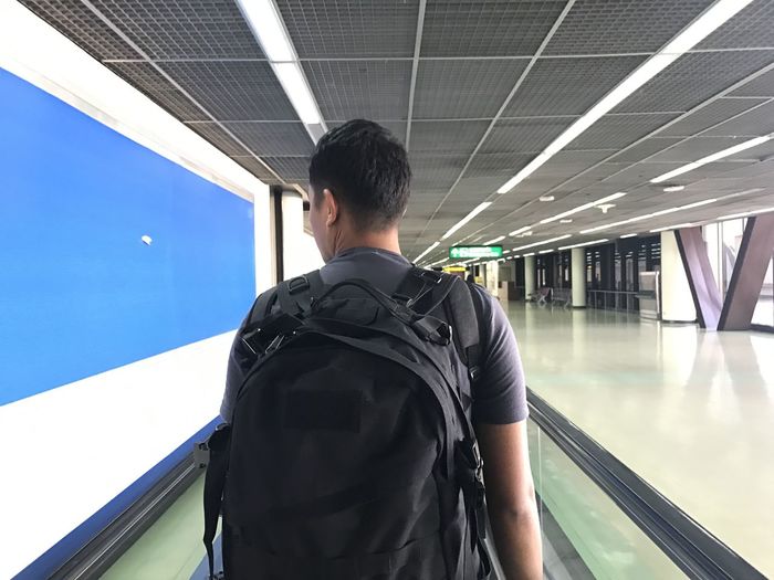 Rear view of backpacker standing in airport