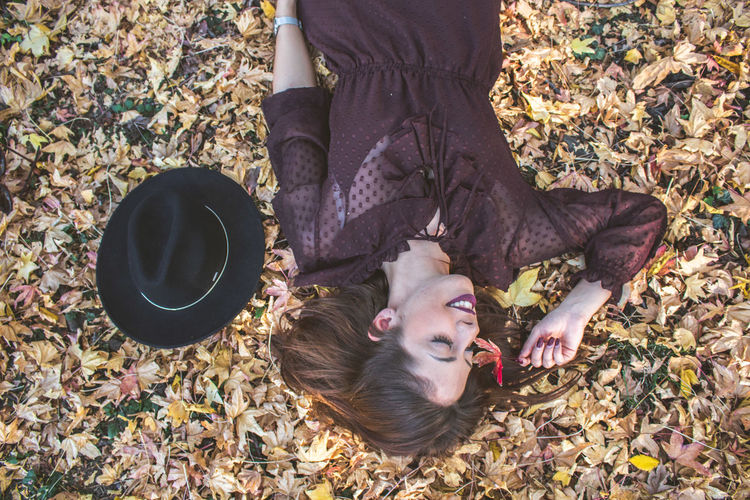 High angle view of woman lying down on land during autumn