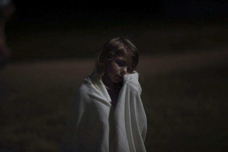 Close-up of girl wrapped in a towel at night