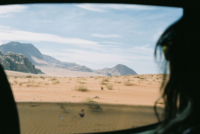 Close-up of woman looking at view through car window in desert