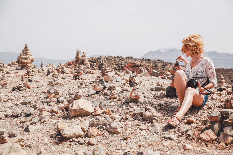 Woman sitting on rocky landscape