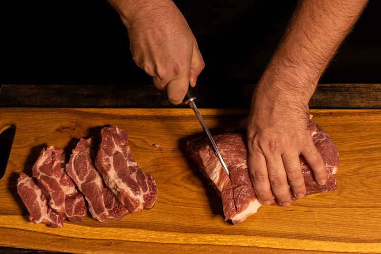 Midsection of man preparing food on cutting board