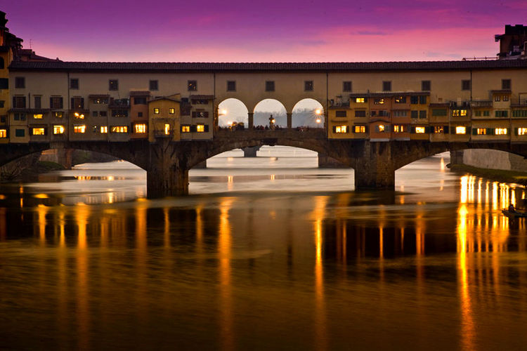 Ponte vecchio over arno river at sunset