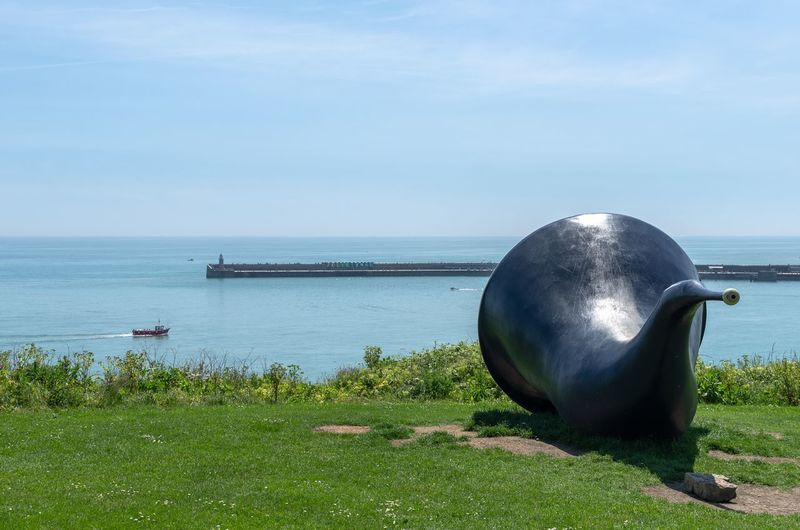 Siren sculpture overlooking the folkestone harbour arm and the english channel in kent, england