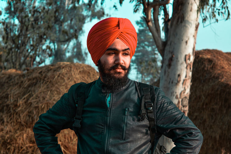 Young man standing against trees