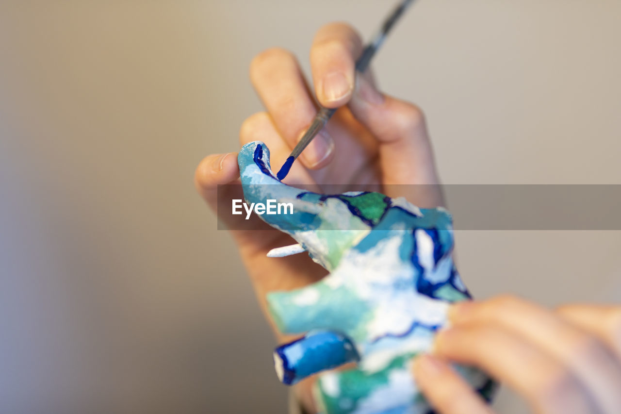 Cropped hand of person painting decoration 