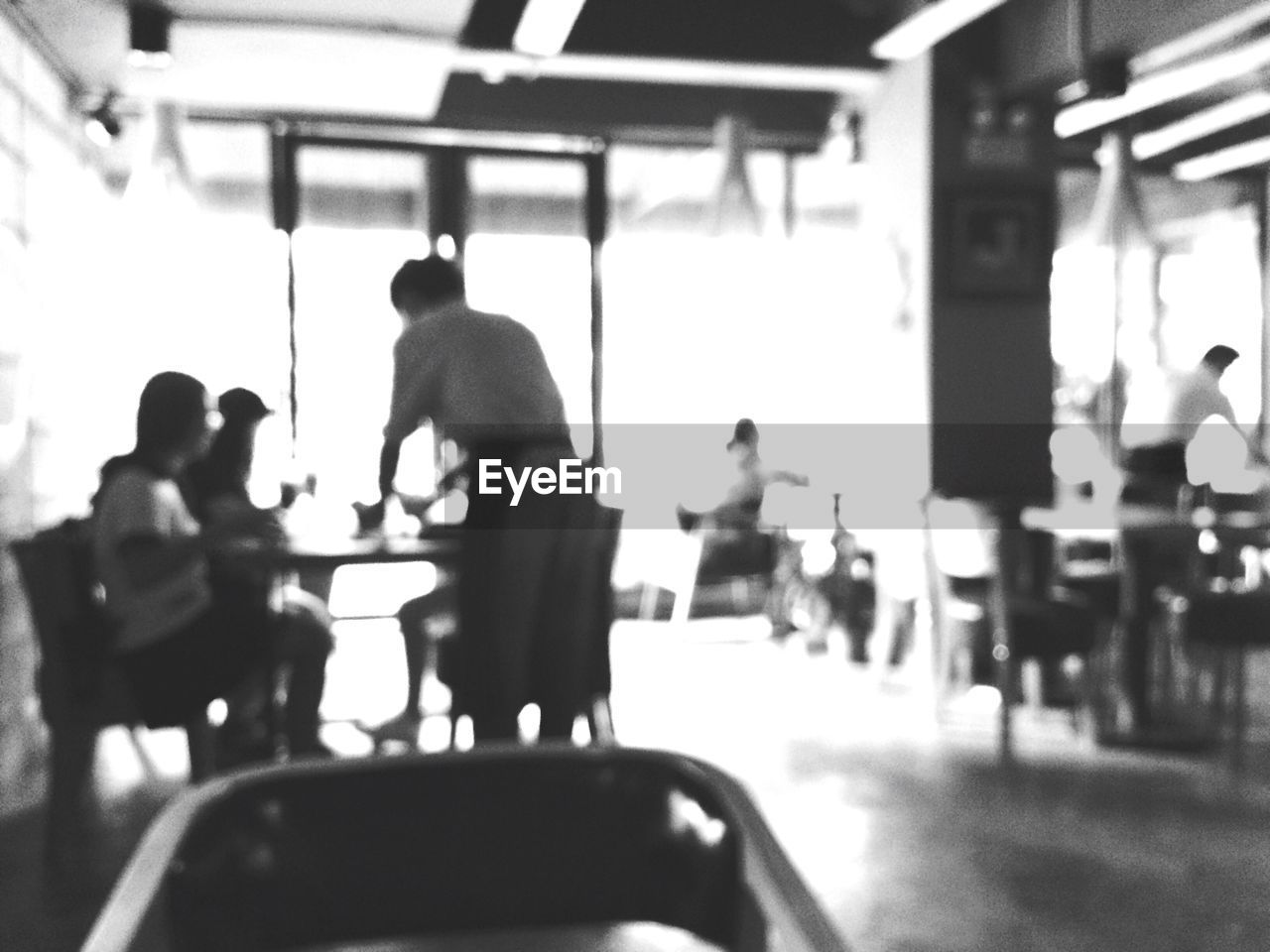 REAR VIEW OF PEOPLE SITTING ON TILED FLOOR