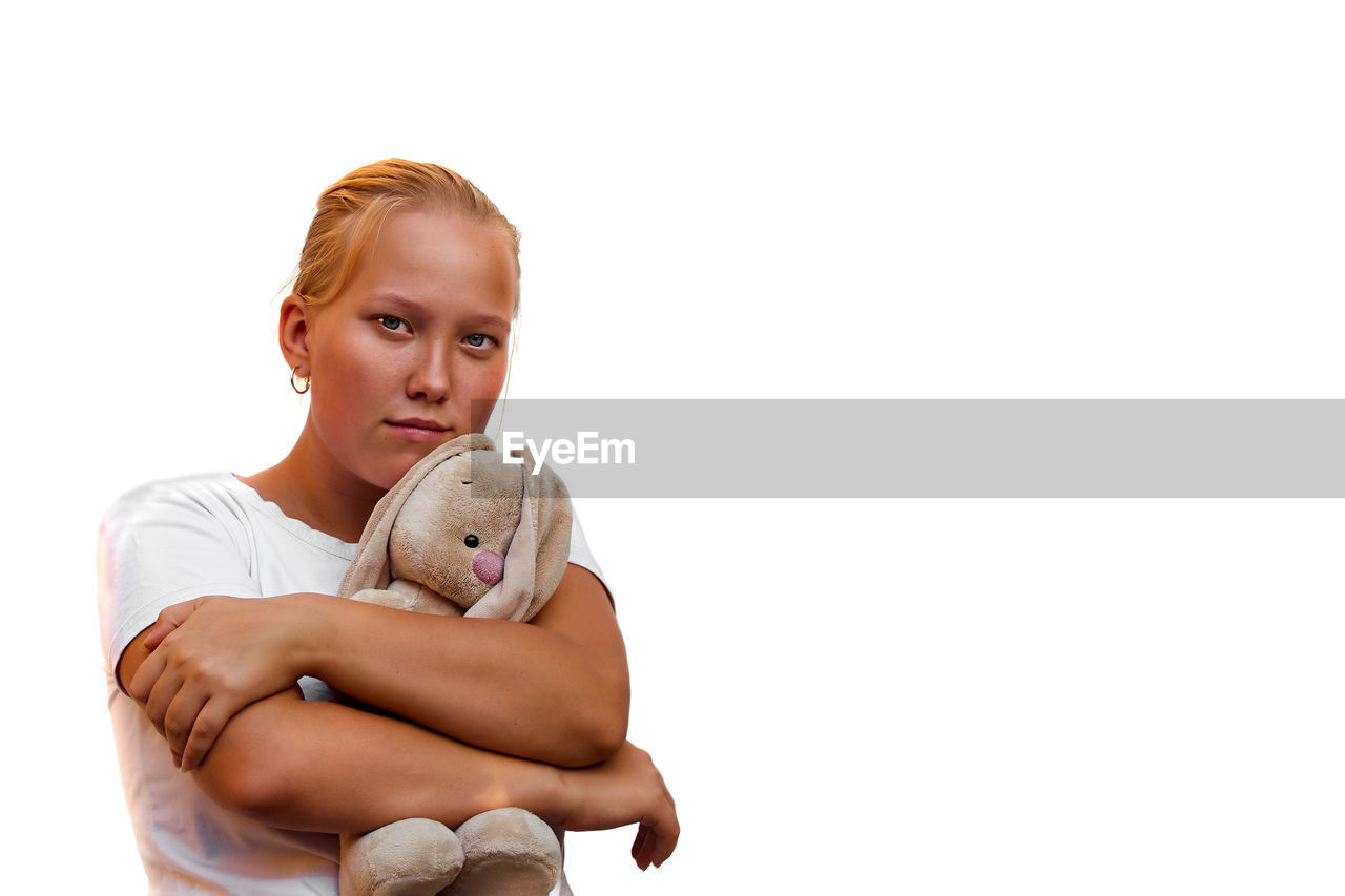PORTRAIT OF BOY WITH TOY AGAINST GRAY BACKGROUND