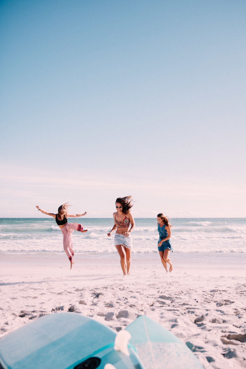 Playful female friends playing at beach