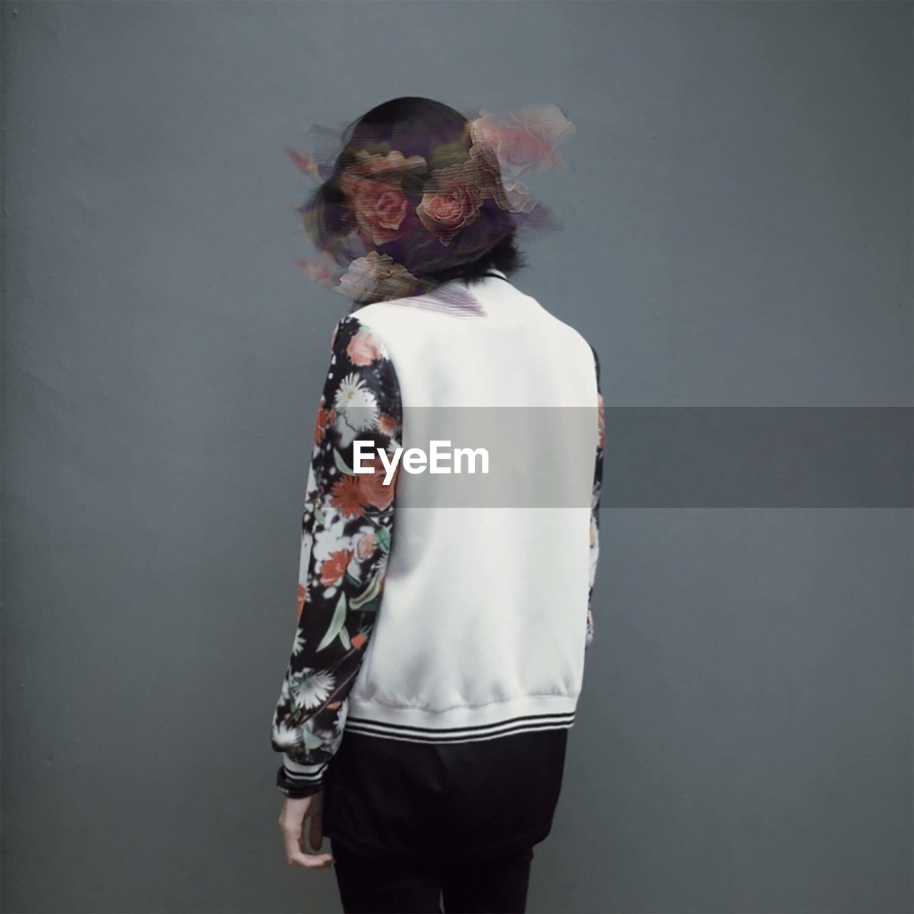 Digital composite image of young woman standing against gray background