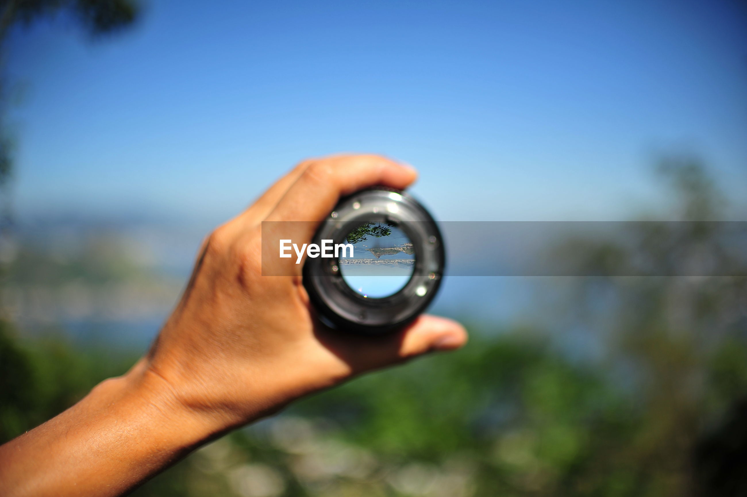 Closeup of hand holding camera lens ID 102556063
